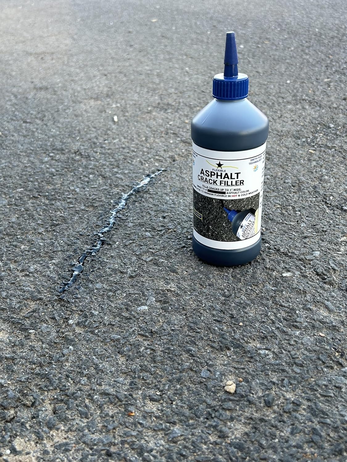 Applying Blue Star Flexible Asphalt Crack Filler to a driveway crack